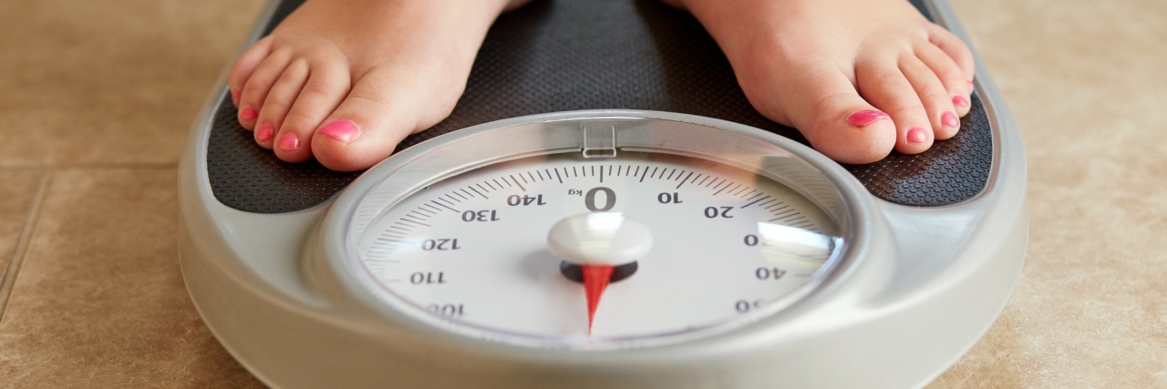 Trying to Lose Weight While Depressed: What to Know A pair of female feet on a bathroom scale