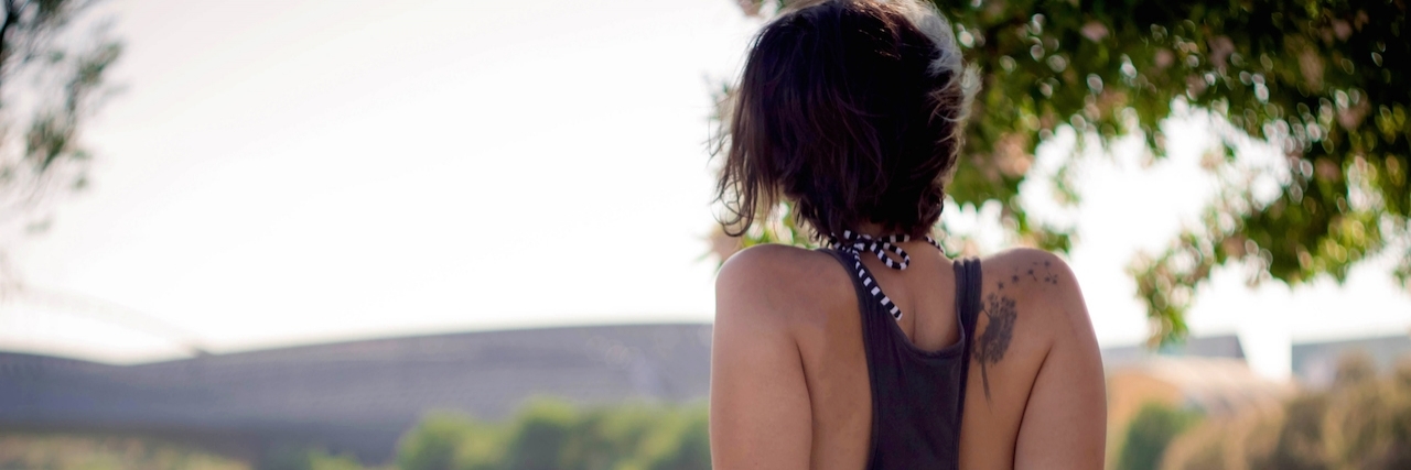 woman sitting in park looking at sky