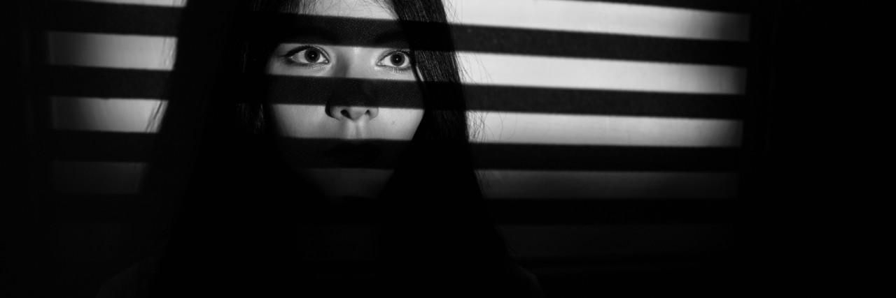 sad scared female portrait in dark with copyspace, monochrome image