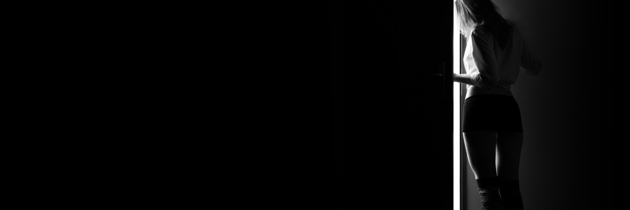 The Anxiety of Being Seen in Public With Vitiligo woman enter to white space from dark, monochrome image with copyspace