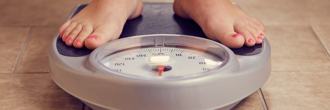Responding to Compliments for Weight Loss Due to Illness A pair of female feet on a bathroom scale