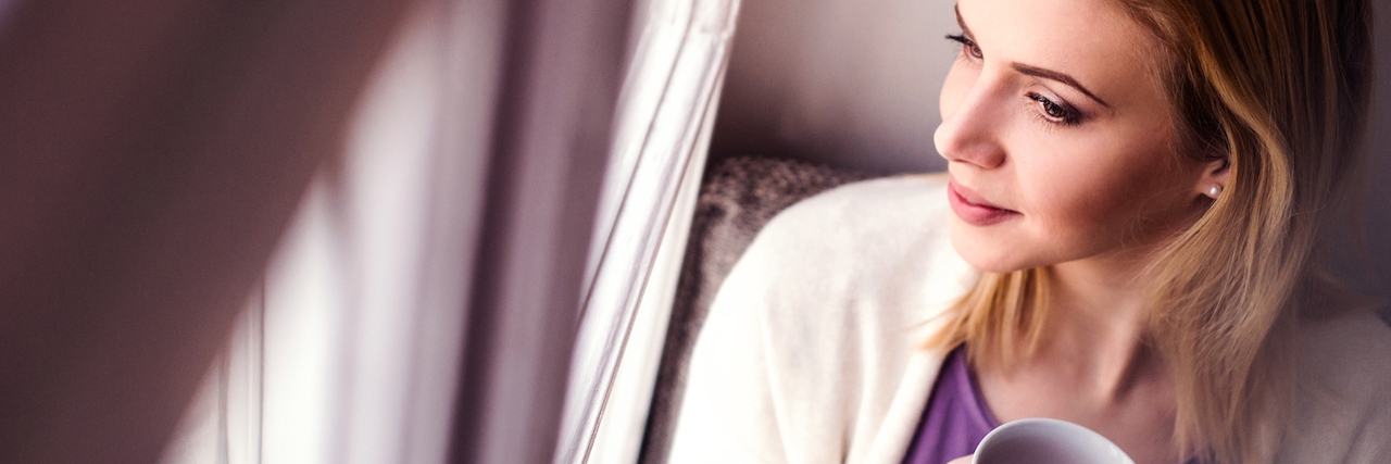 Quotes to Help You Through Depression Woman on window sill holding a cup of tea