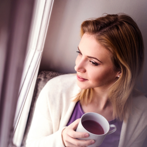 Woman on window sill holding a cup of tea