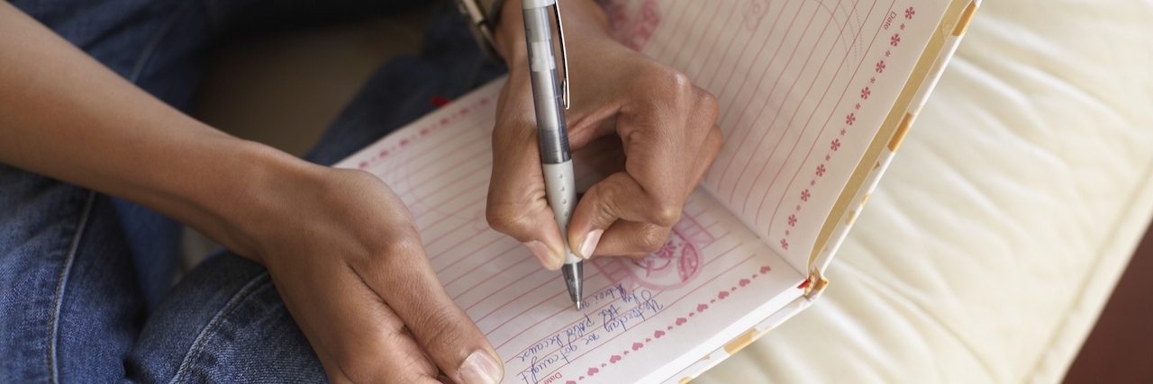Self-Care Tips for Suicide Loss Survivors Woman's hands writing in journal