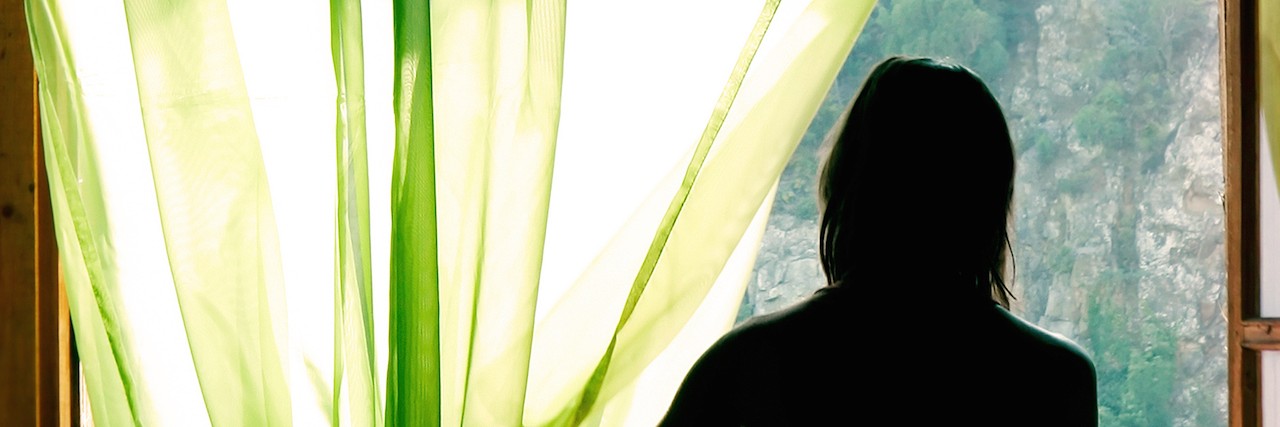 Getting Diagnosed With Generalized Anxiety Disorder After 45 Years Female silhouette at open window in old hotel