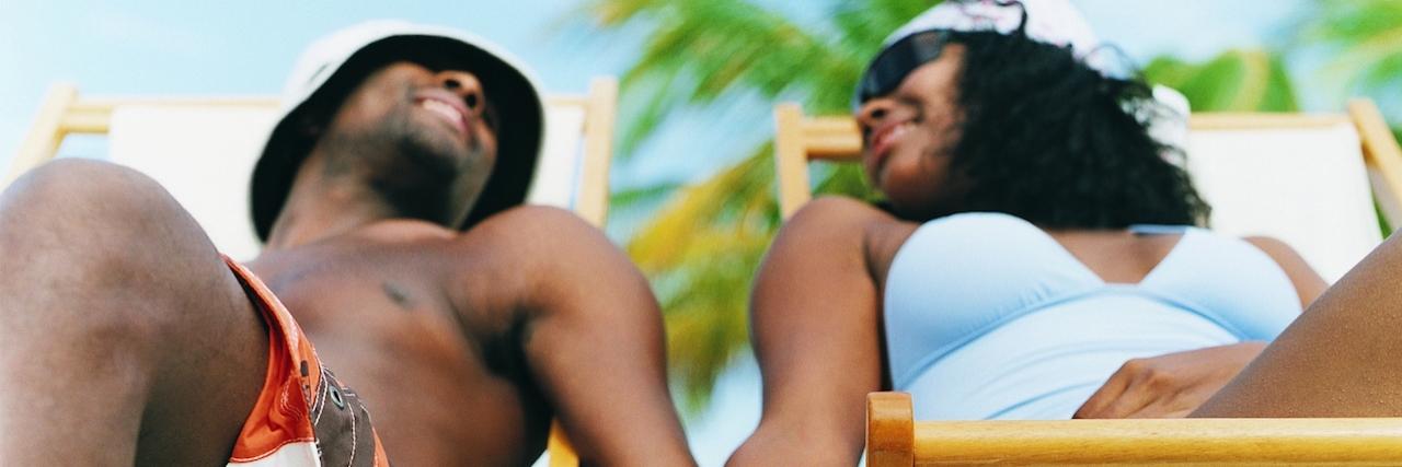 Loving a Person Who Has Depression Couple Sitting on Deck Chairs, Holding Hands on the Beach