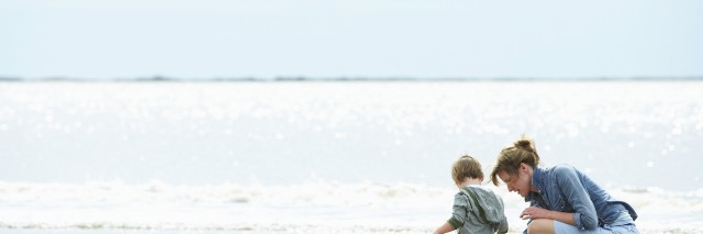 Mother and son playing on the shore of a beach