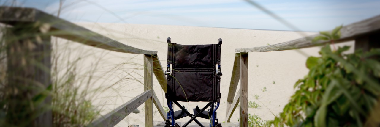 The Beach By Our Vacation House is Inaccessible to Wheelchairs Wheelchair on a beach boardwalk with steps.