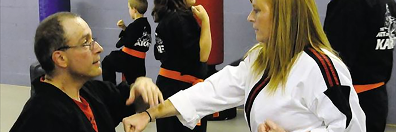 How Earning a Black Belt in Karate Changed My Life With a Disability Paul Brailer with a martial arts student.