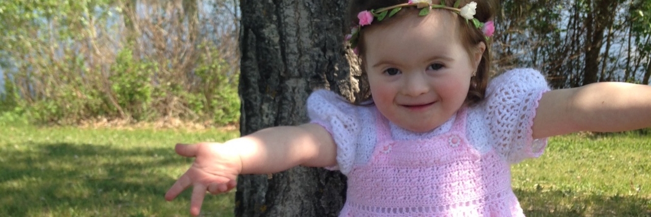 Responding to People Who Don't Understand Down Syndrome The author's daughter, standing in front of a tree with her arms open