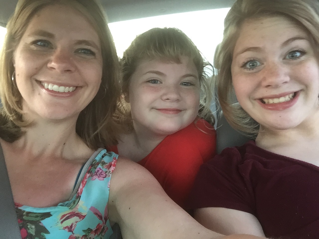 mom and two daughters in the car