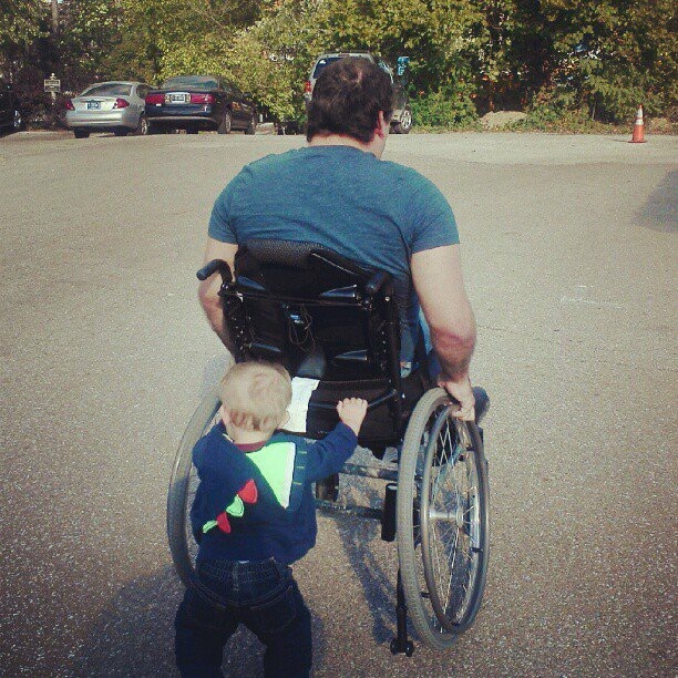 Christine's son pushes his father's wheelchair.