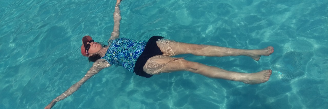 woman floating in a swimming pool on her back