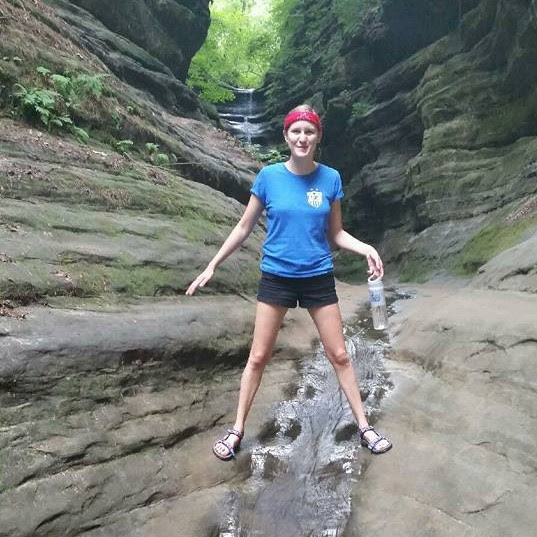 woman in forest standing over creek