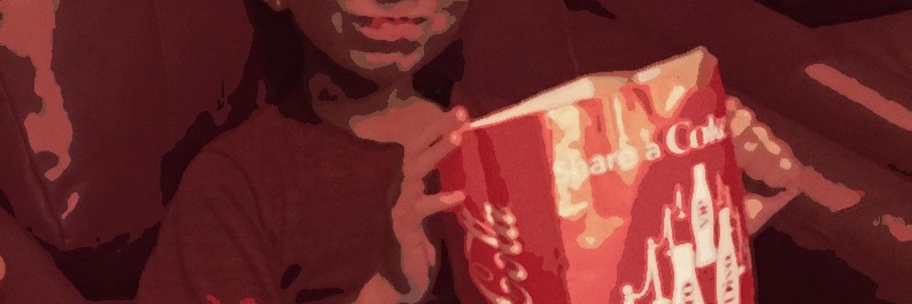 'Finding Dory' and Parenting a Child With Sensory Processing Disorder little boy with popcorn in lap at the movies