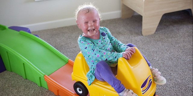 Courtney's daughter riding a toy car