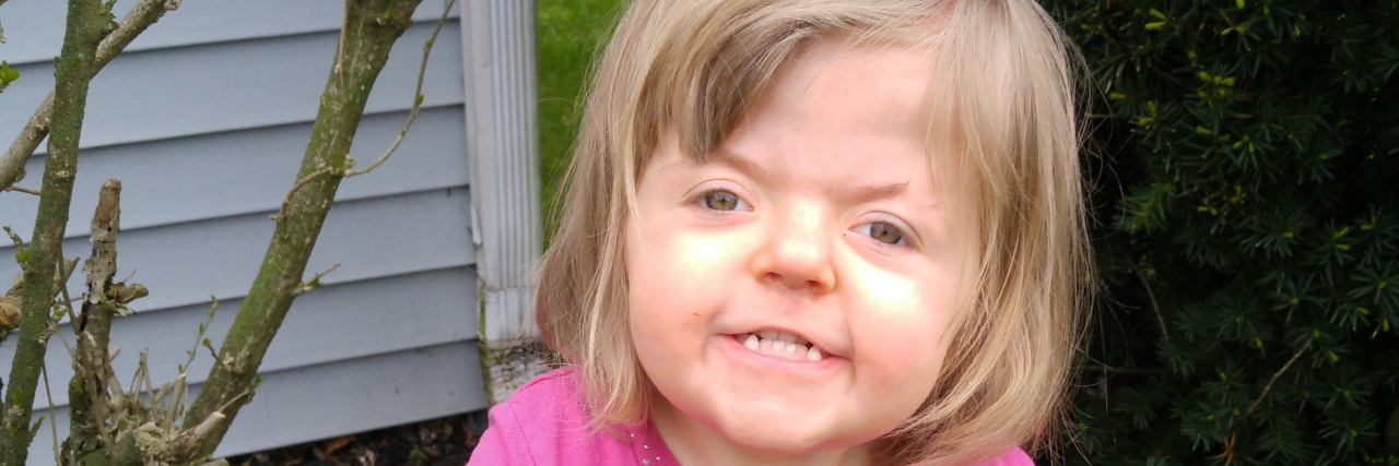 Learning to Accept Your Child's Apert Syndrome Diagnosis Jeannie's daughter smiling in their yard