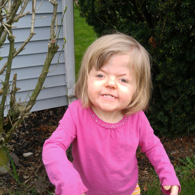 Jeannie's daughter smiling in their yard