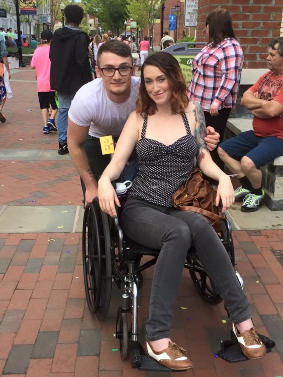 woman in wheelchair with man standing behind