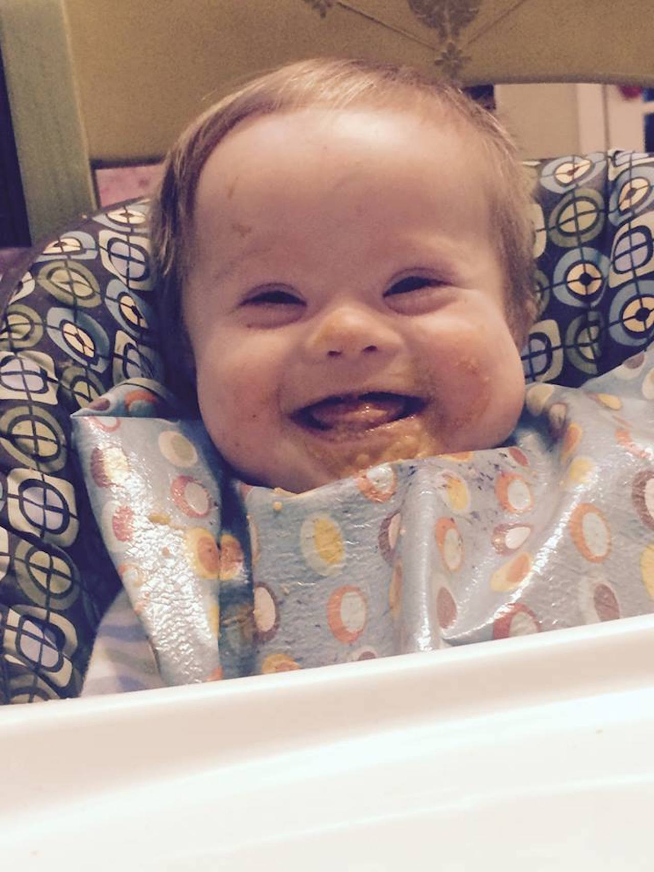 baby with down syndrome eating cake