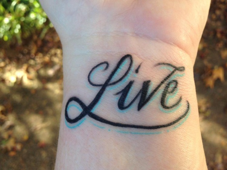 tattoo on wrist that reads: live