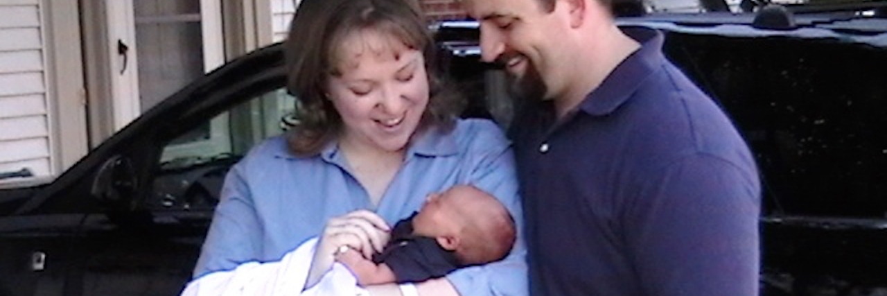 Telling Others We’re Going to Be a Special Needs Family The author holding her baby with her husband standing next to them