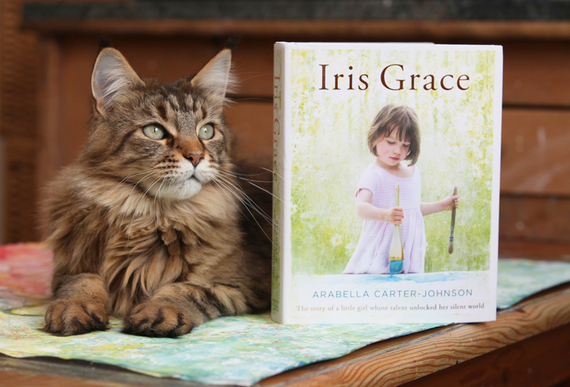 Thula the cat poses with a copy of Arabella Carter-Johnson's new book "Iris Grace."