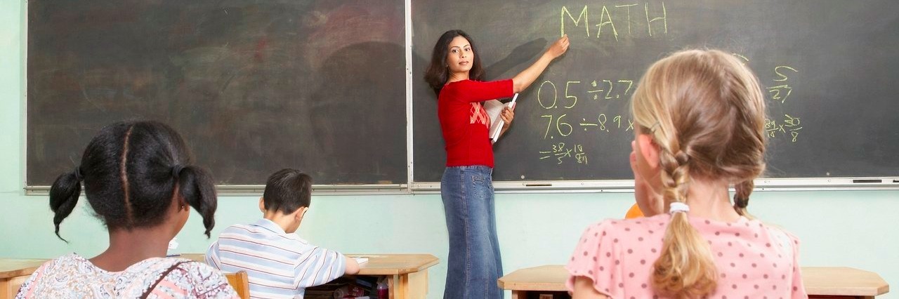 A Letter to the Teacher of My Child With Anxiety teacher pointing to blackboard in class