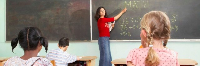 teacher pointing to blackboard in class