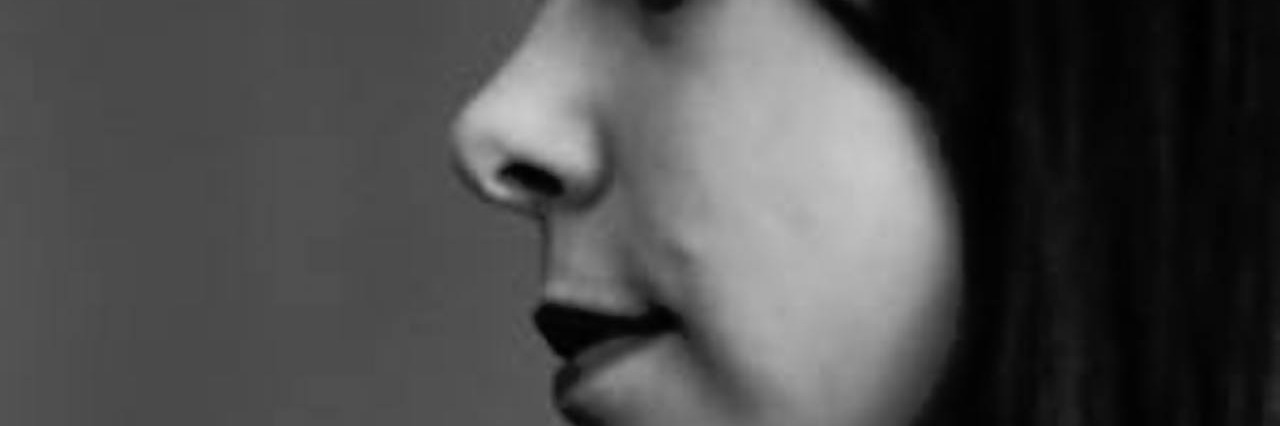 When Depression Silently Stalks Your Mind A woman holds her hand toward her face.