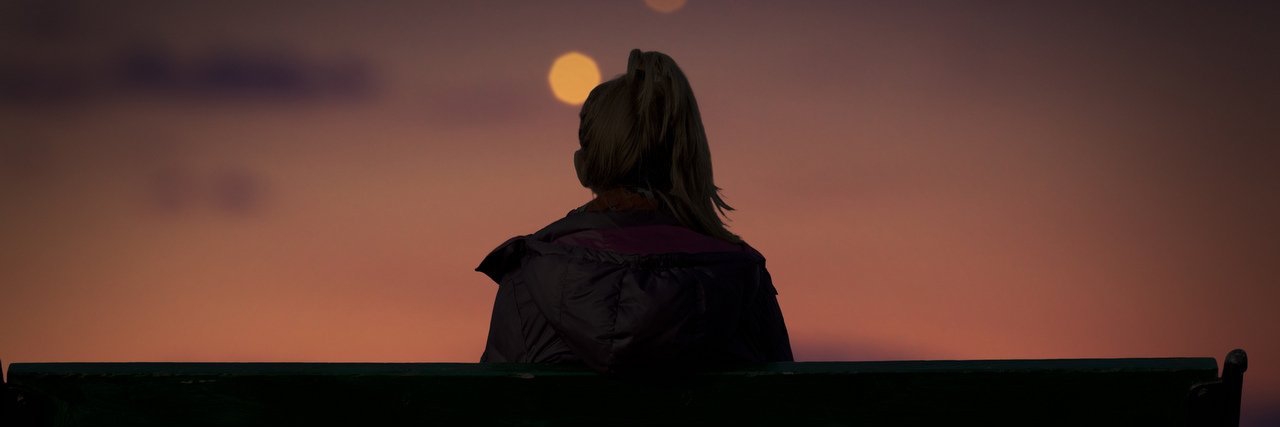 Child Loss: Our Grief Is a Never-Ending Journey woman sitting on a bench at night