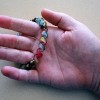 A hand holding a colorful bracelet
