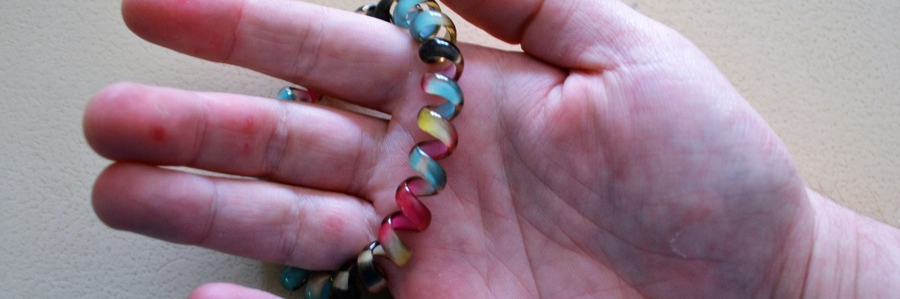 Using a Bracelet to Help Manage My Anxiety A hand holding a colorful bracelet
