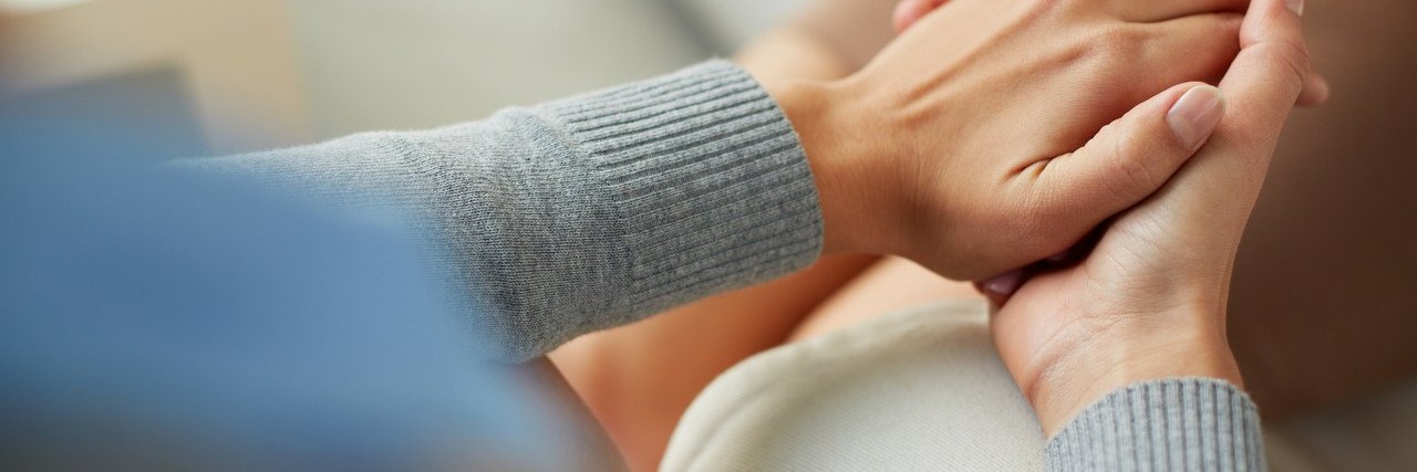 Hunter Syndrome: A Death Affects Everyone in Our Community person consoles another by holding their hand