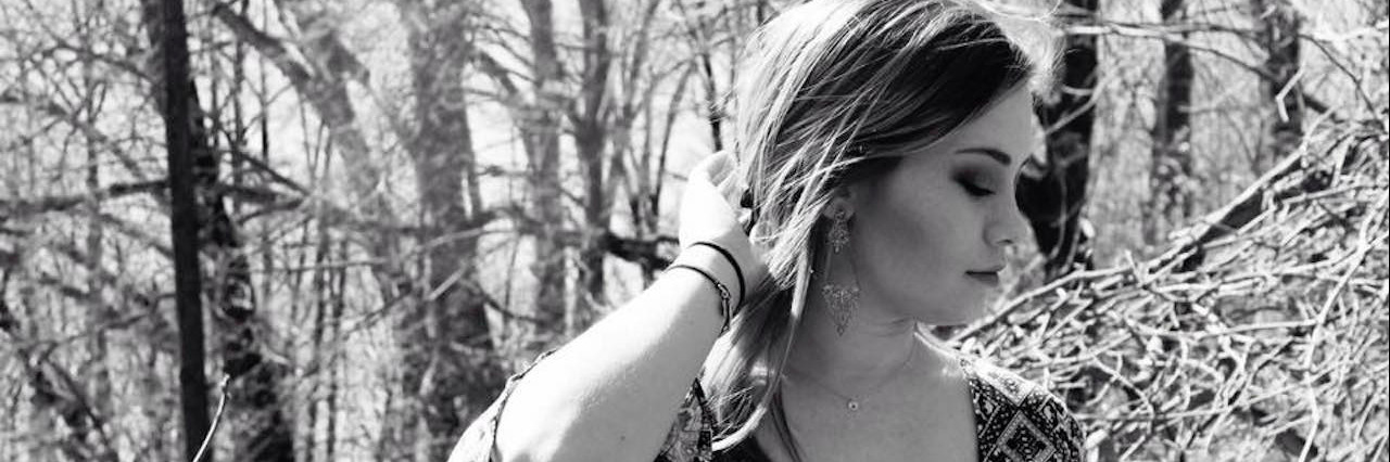 Having Anxiety About Sharing Your Story About Anxiety A woman standing in the woods looking away from camera.