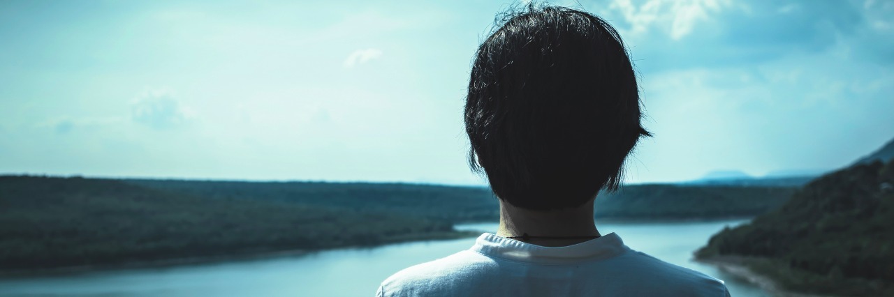 A Letter to My Parents After I Was Diagnosed With a Chronic Illness young woman standing on top of a mountain