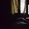 woman laying on bed near window