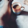 legs in bed with coffee mug