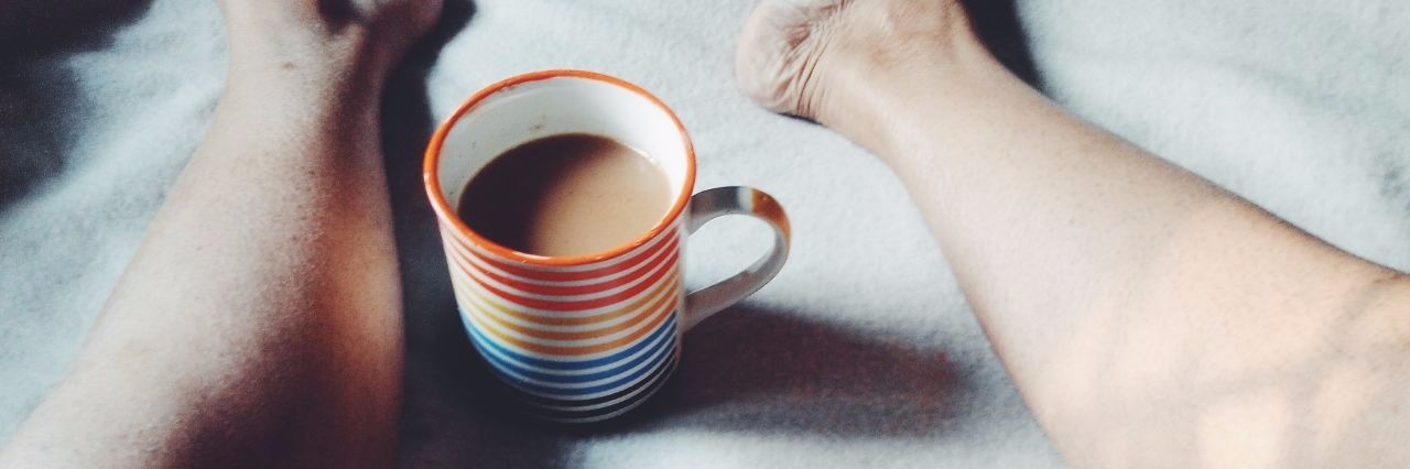 Tips for What to Do on Bad Flare-Up Days of Illness legs in bed with coffee mug