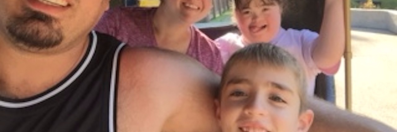 Answering My Sons Questions About His Sister With Down Syndrome family of four in a car