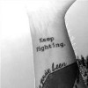 two tattoos: One wrist says "keep moving" other other says "keep fighting."