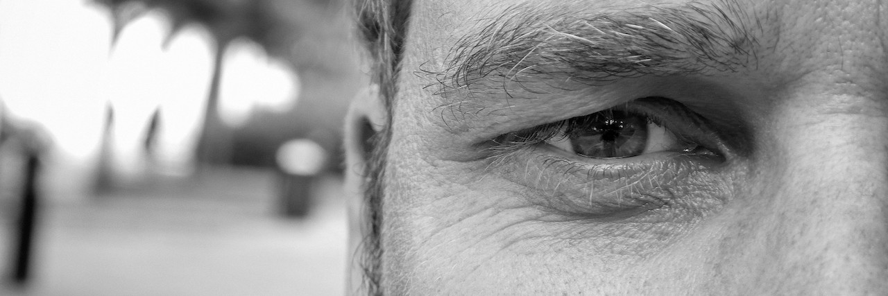A black and white close-up photo of half of a man's face