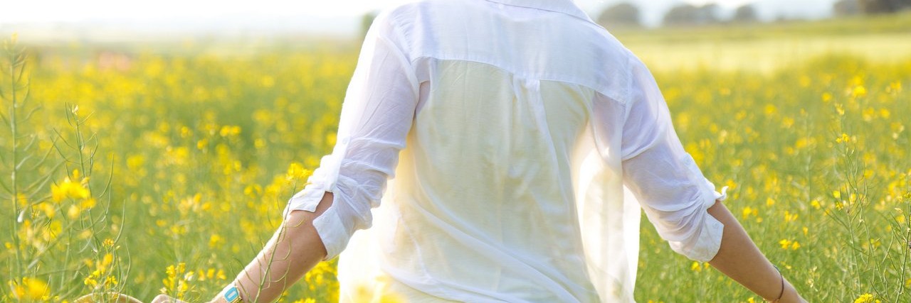 Chronic Fatigue Syndrome: I’m Learning to Be Kinder to Myself young woman enjoying summer in a field