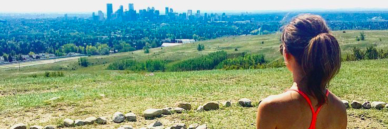 Eating Disorder Recovery: Lessons I've Learned Woman overlooking a city skyline from a hill with her dog next to her