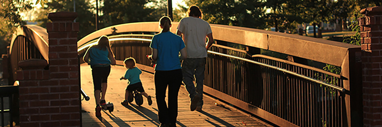 Family walking across a bridge.