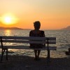 woman sitting on a bench and watching the sunset