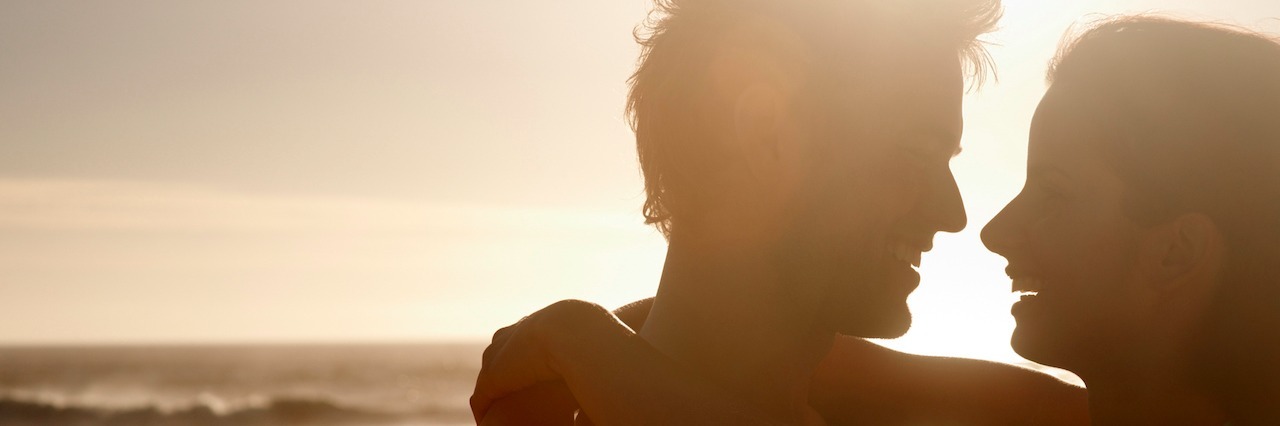 Young couple in love, hugging at sunset