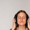 Young woman listening to music on headphones.