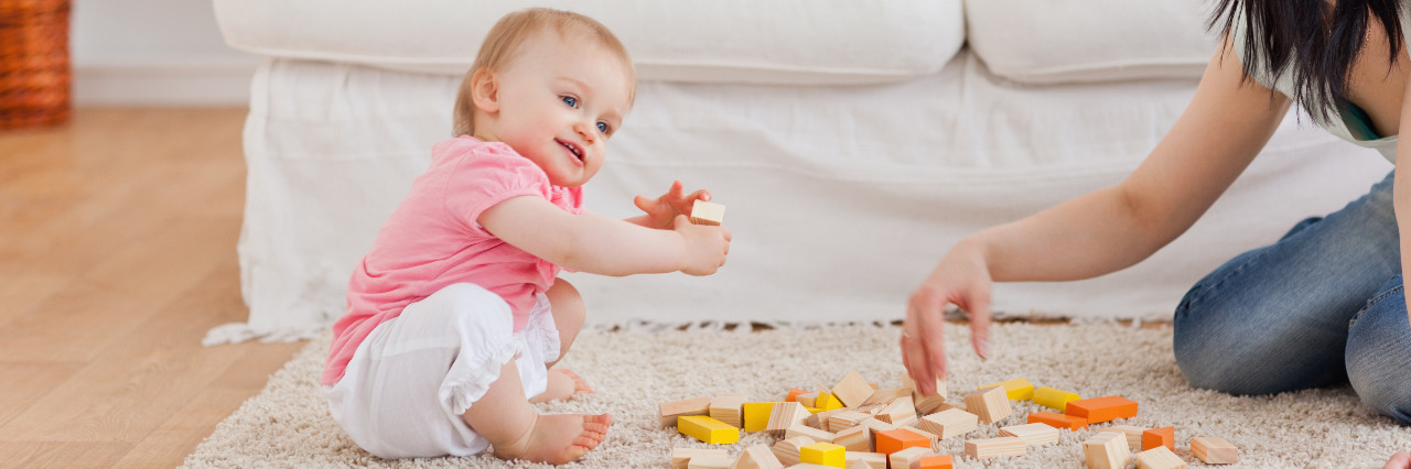 Advice for Parent of a Child With Autism From an Adult On the Spectrum Woman playing with her baby.