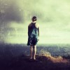 Lonely woman looking at ocean vista over textured grunge background.